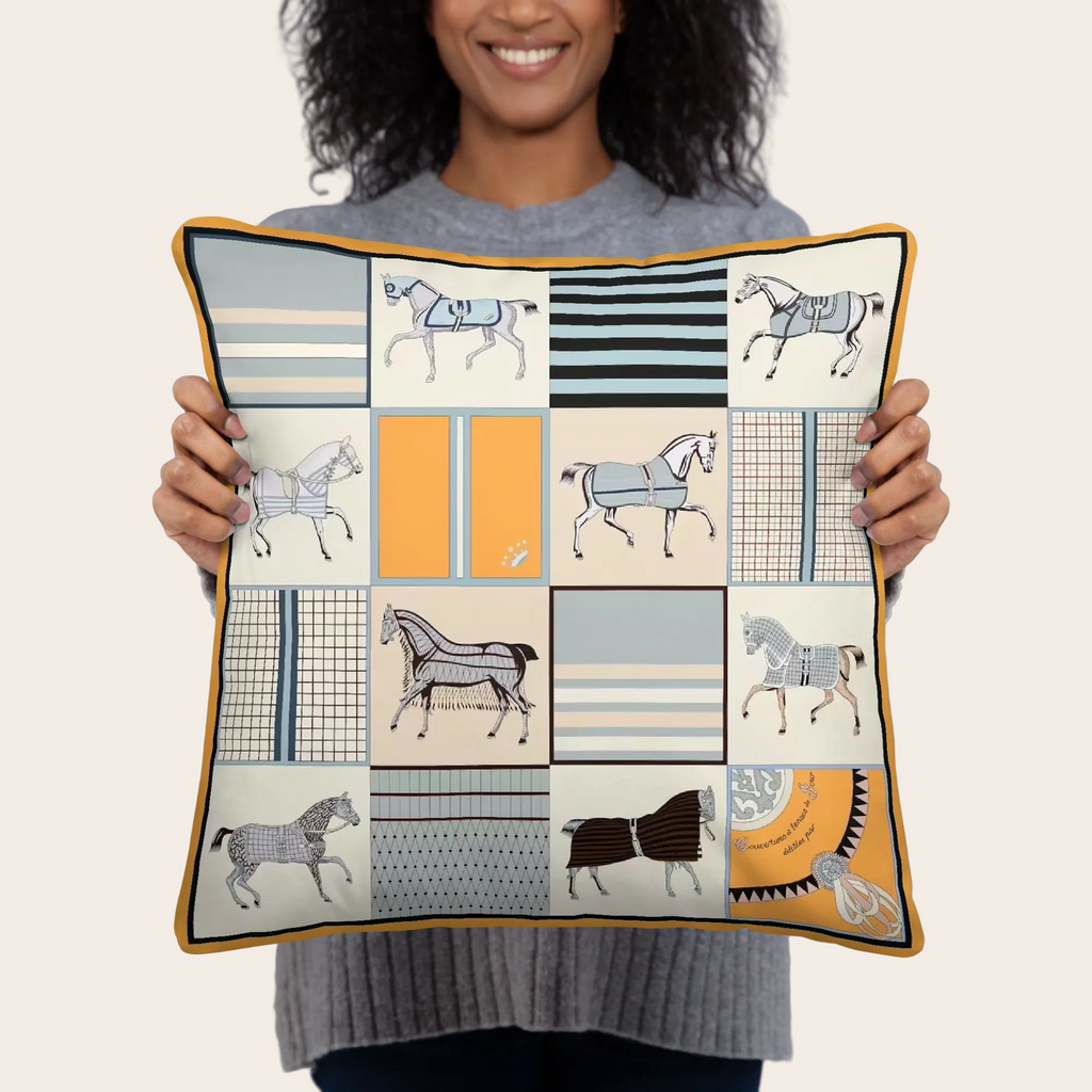 Person holding a decorative pillow with vintage horse patterns.