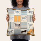 Person holding a decorative pillow with vintage horse patterns.