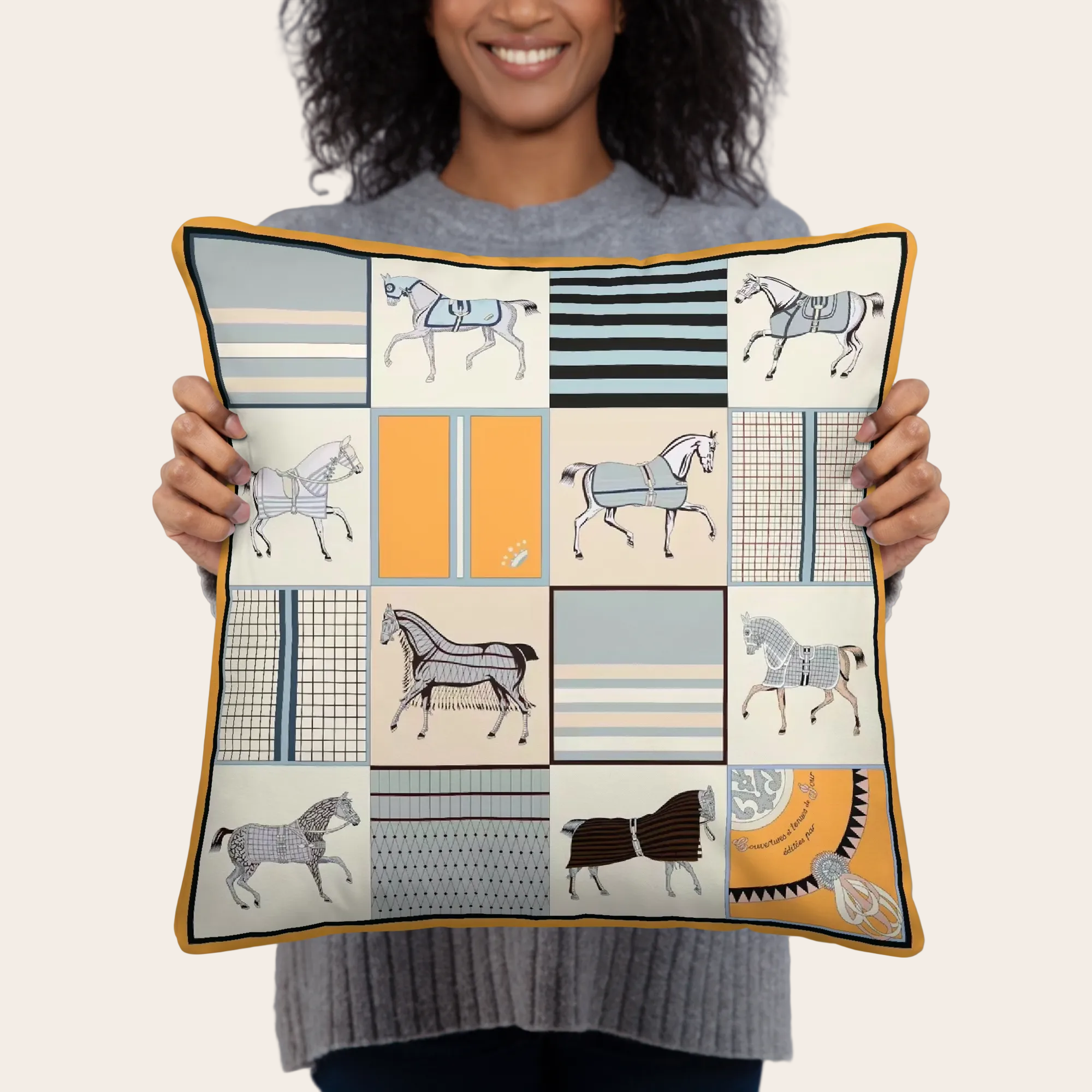Person holding a decorative pillow with vintage horse patterns.