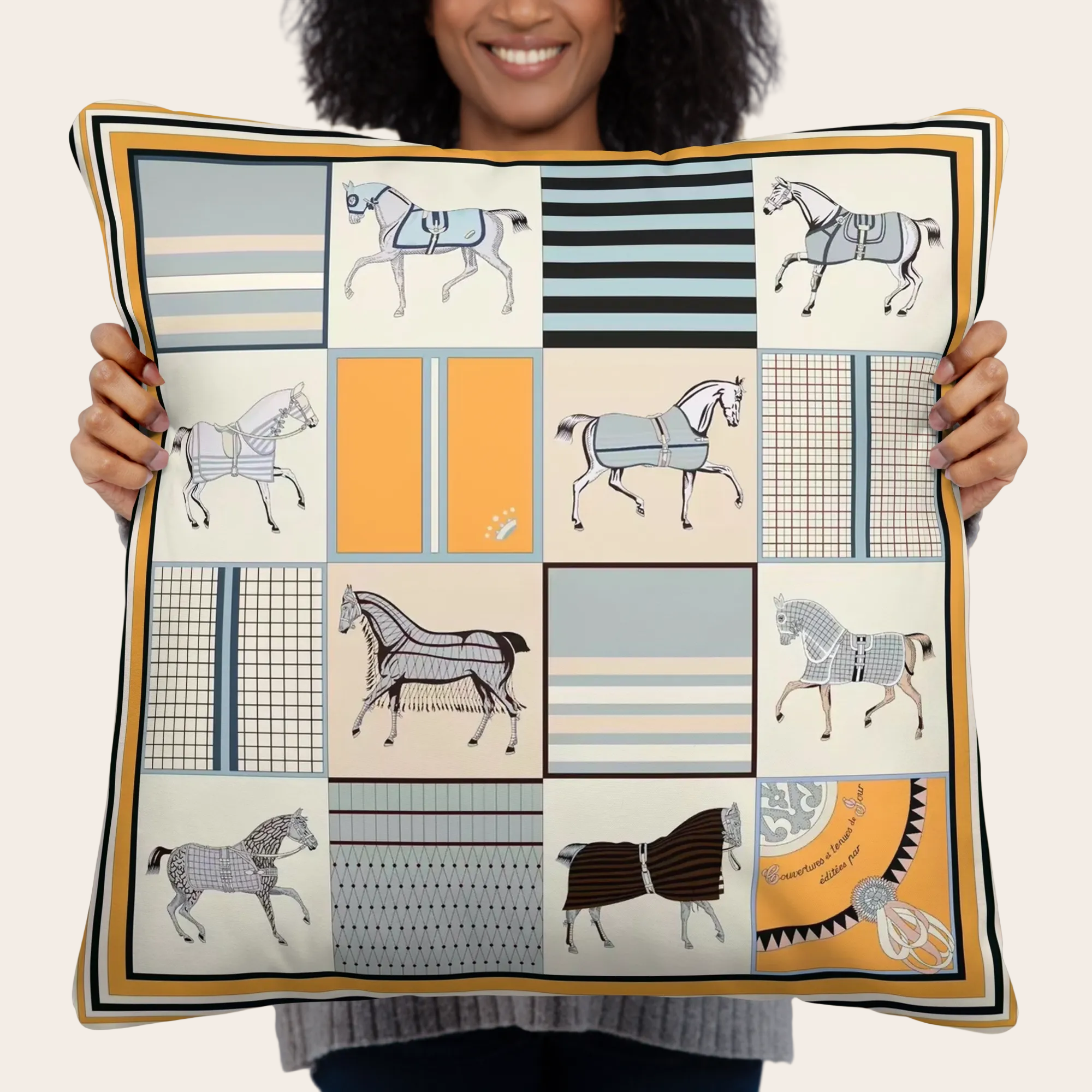 Person holding a decorative pillow with vintage horse patterns.