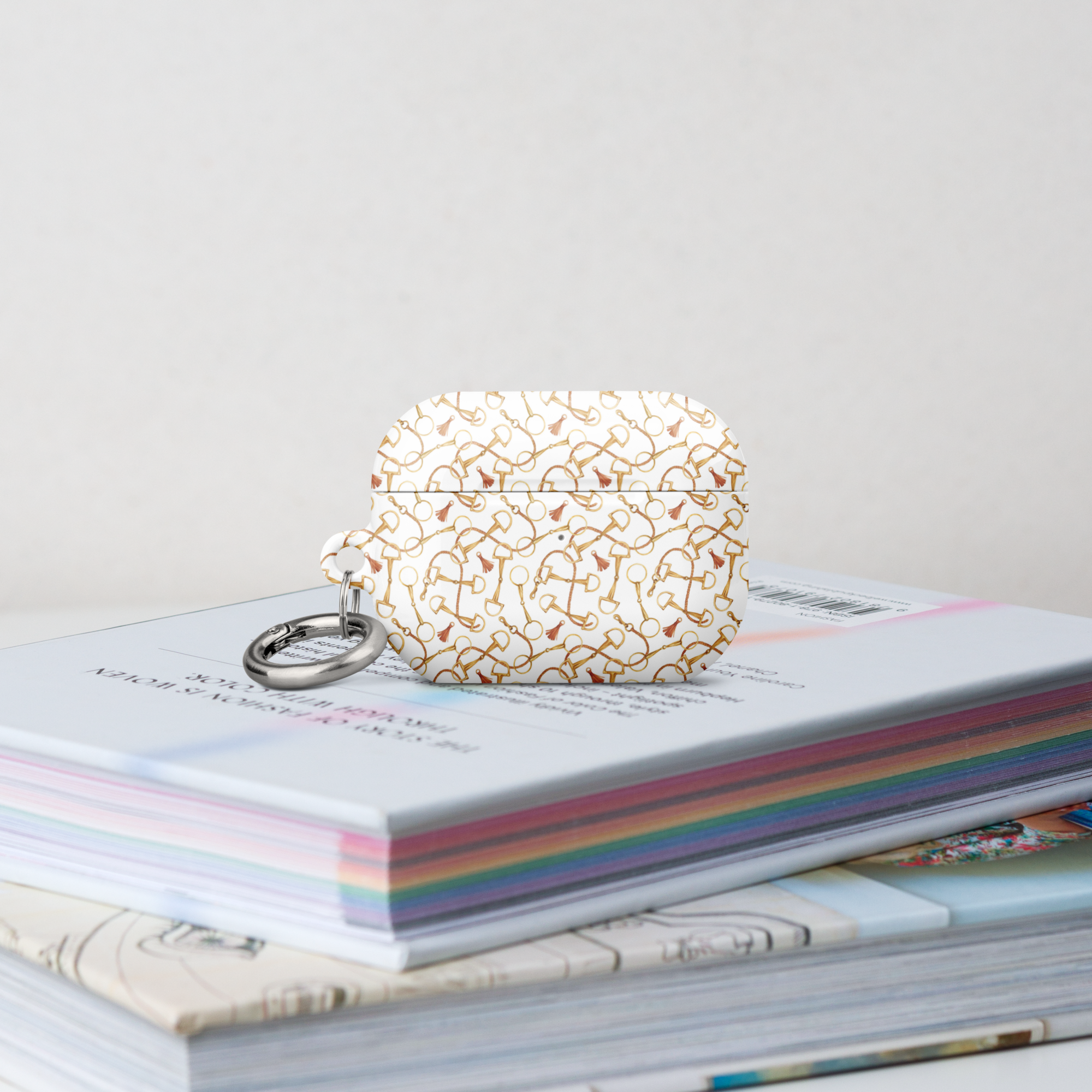 Pretty Case for AirPods with intricate design on top of a colorful book