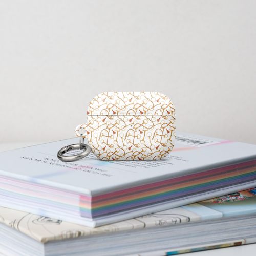 Pretty Case for AirPods with intricate design on top of a colorful book