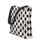 Tote bag with black strap and black and white pattern.
