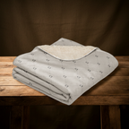 Folded blanket with stirrup patterns on a wooden table against a brown background