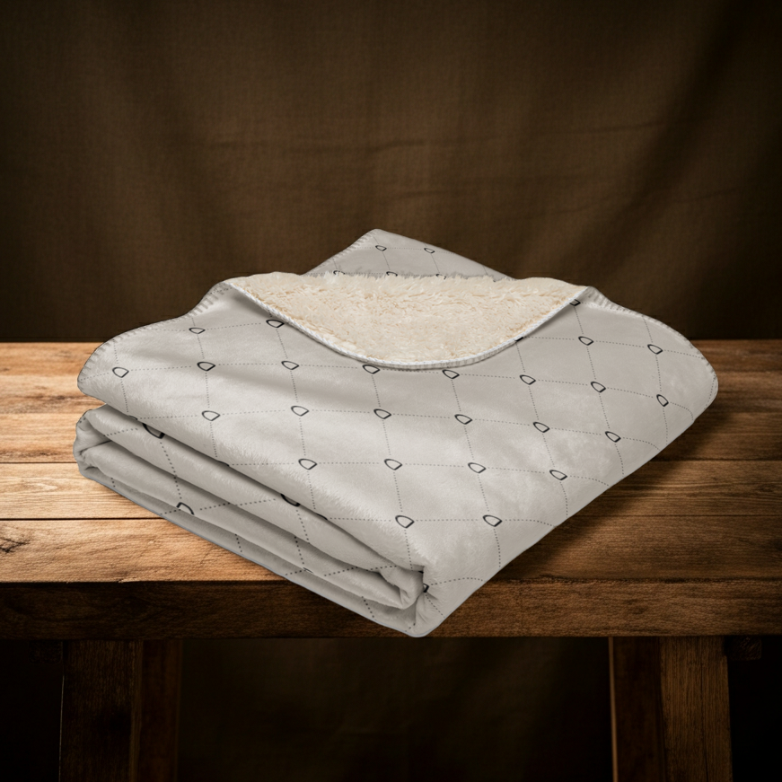 Folded blanket with stirrup patterns on a wooden table against a brown background
