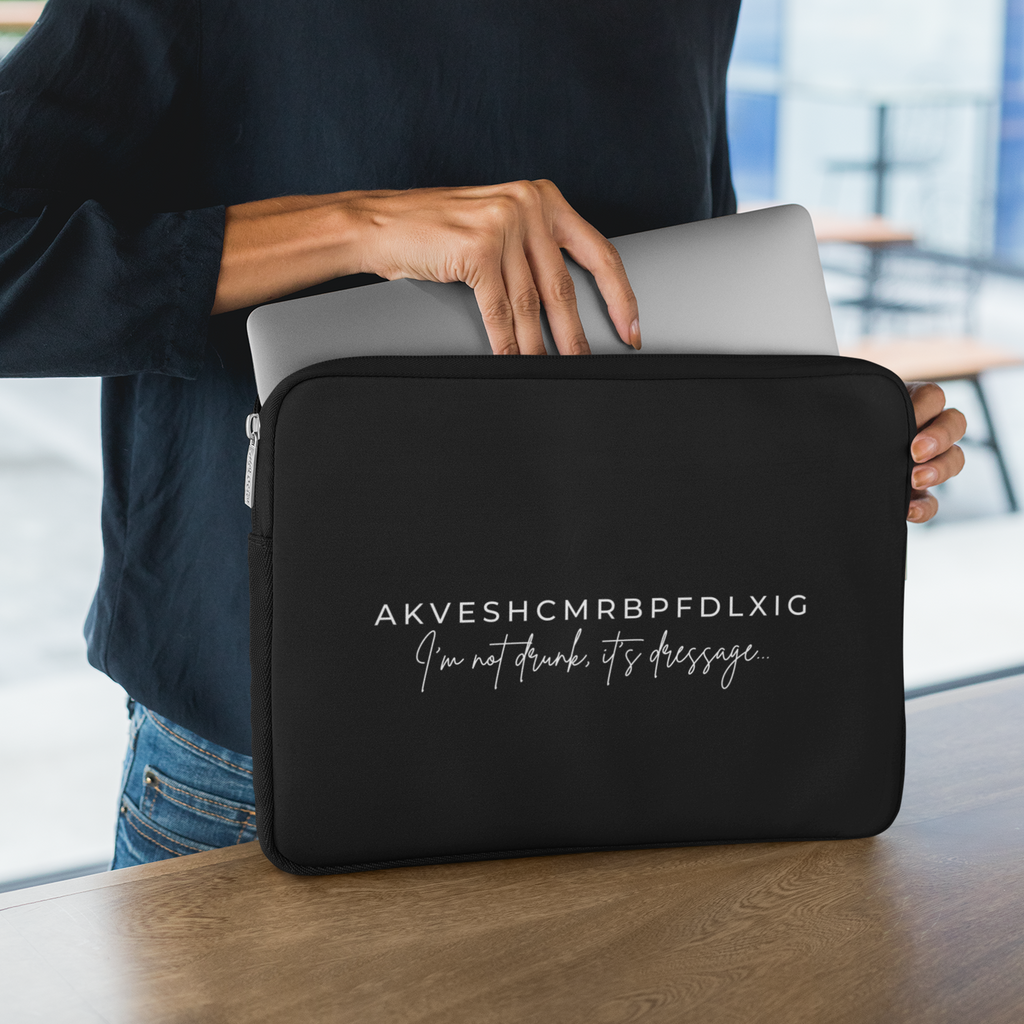 Woman holding a laptop in a black sleeve with text