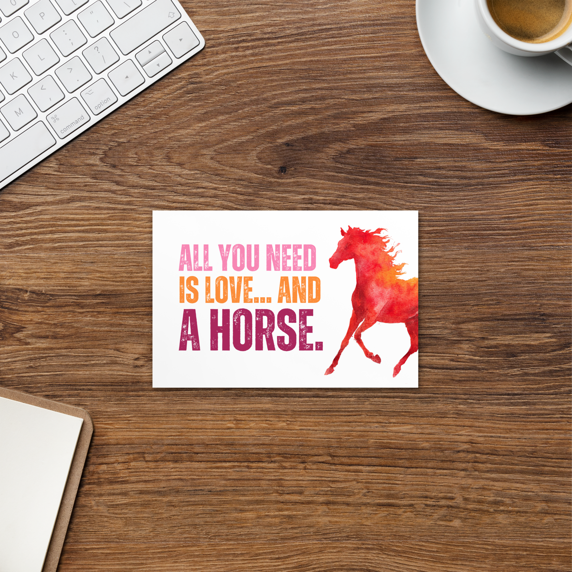 Desk with a card featuring a horse and text, keyboard, and coffee cup in the background.